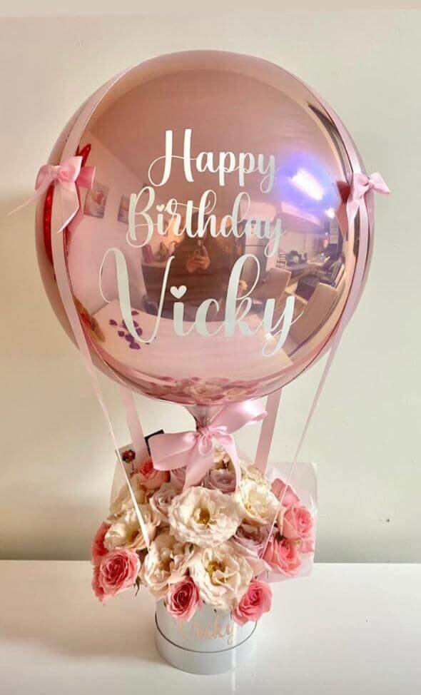 Rose gold colored hot air balloons and beautiful flower gift hamper with white and rose flowers