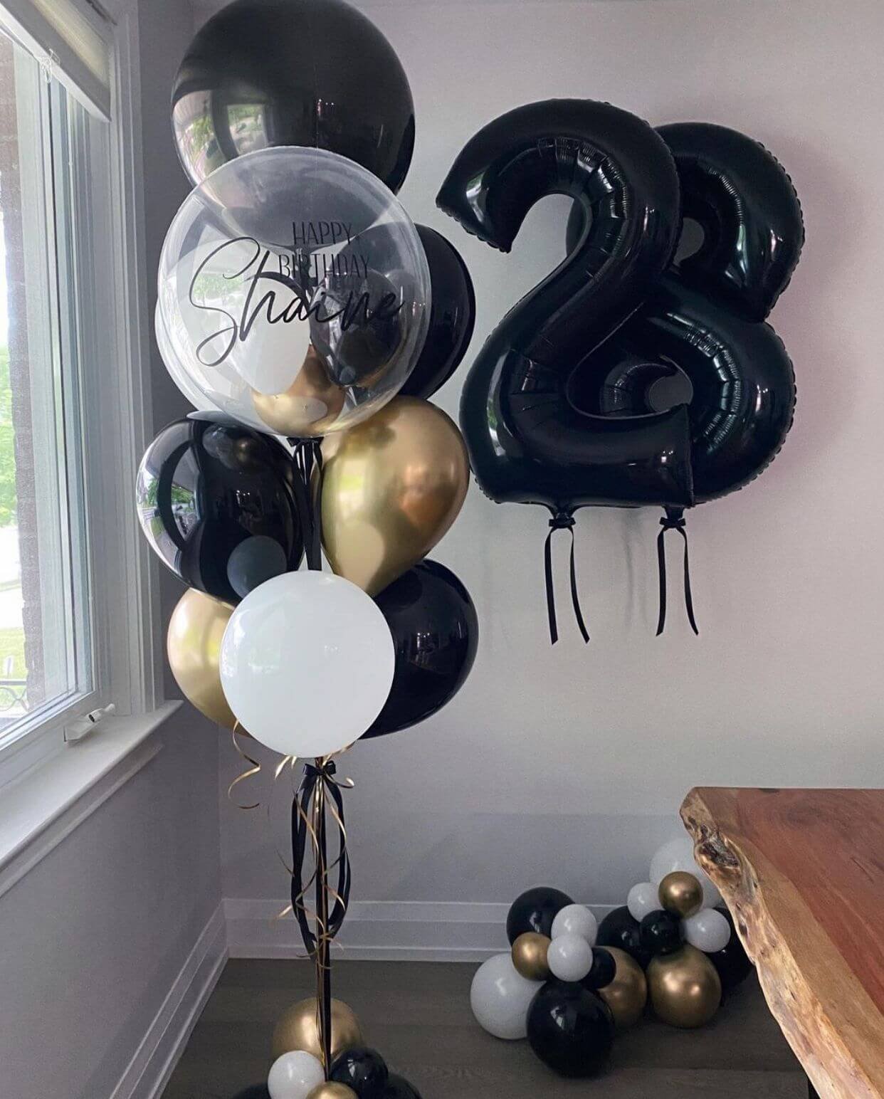 black,gold and white customized balloon bouquet for birthday with numbered foil balloon